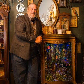 Scott Soffa posing next to the Fairy Cabinet he created