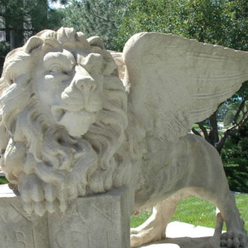 Limestone sculpture of winged lion with front right paw on book by unknown artist