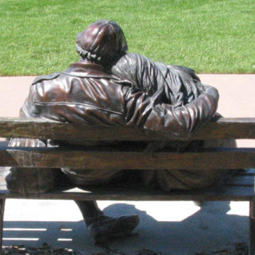 Bronze sculpture of man and woman on a bench by George Lundeen