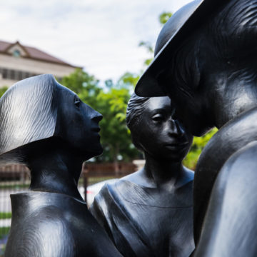 Bronze sculpture of three woman huddled closely by Harry Marinsky