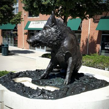 Bronze sculpture of boar seated on hind legs