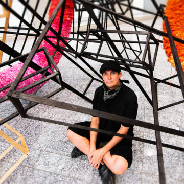 Scottie Burgess sits under his abstract sculpture